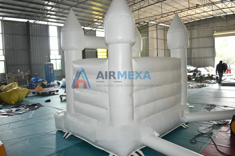 Castillo inflable blanco para bodas instalado en jardín de evento elegante