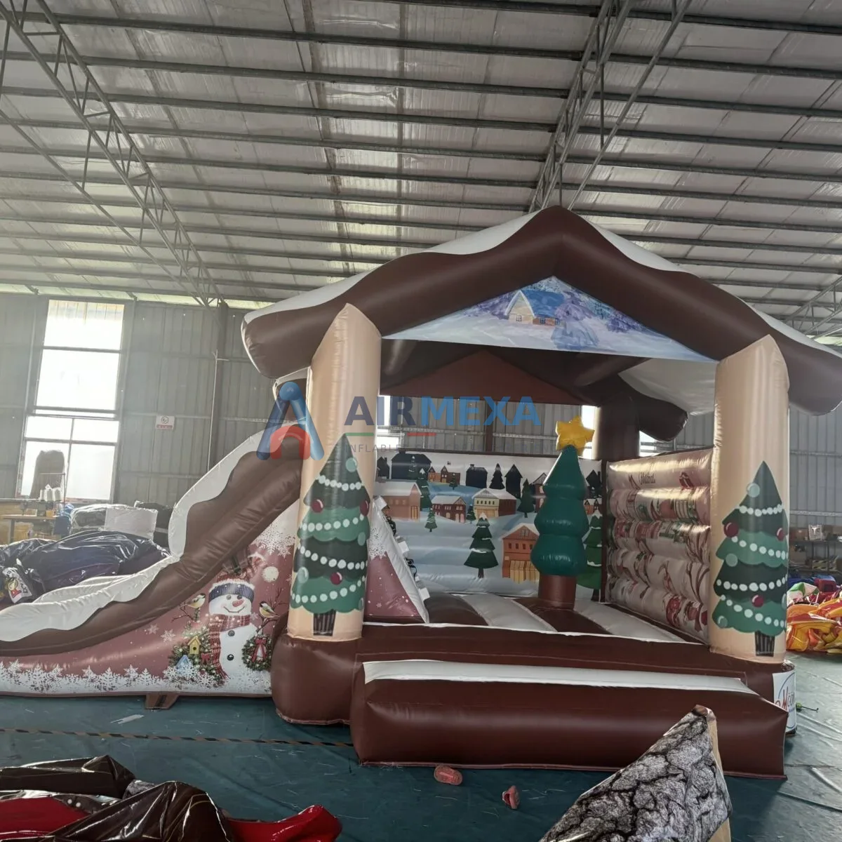 Castillo inflable combo con temática navideña y resbaladilla en evento comercial