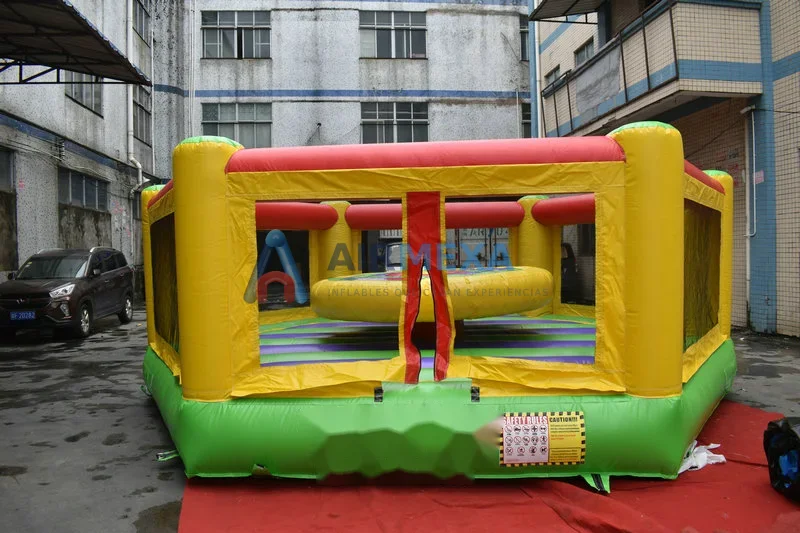 Arena inflable de justas con dos jugadores en pedestales usando varas acolchonadas