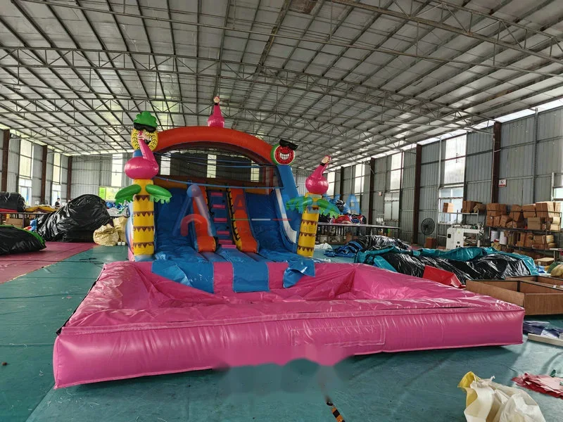 Resbaladilla inflable con temática de flamingo instalada junto a una alberca